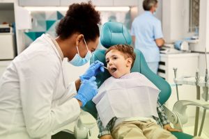 Little boy sitting on a dental treatment chair during a routine check-up with Calgary dentist Dr. Brent MacDonald, friendly pediatric dental care.