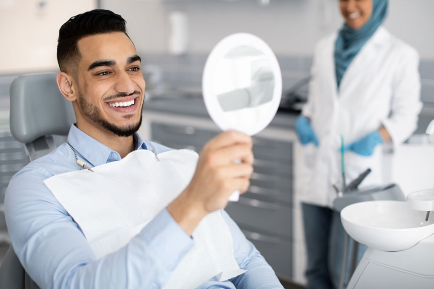 Man Inspecting His Teeth After Teeth Bonding In NE Calgary, AB